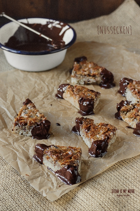 Caramel Nut Bars decorated with chocolate and placed on a piece of parchment paper.
