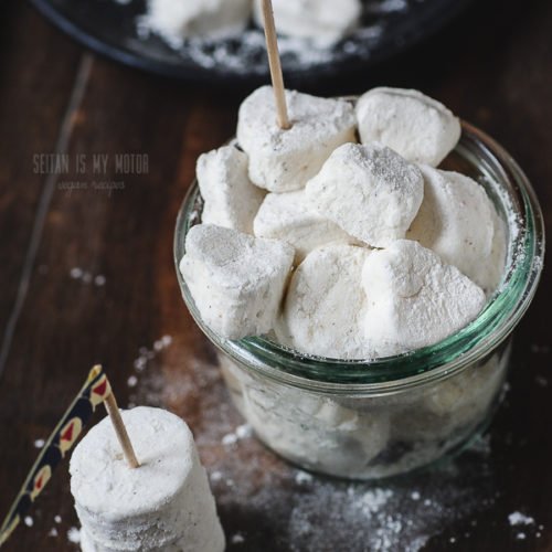 Ein Glas voller veganer Marshmallows auf einem Holzuntergrund