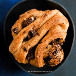 One Franzbrötchen with Chocolate Chunks in a black bowl.