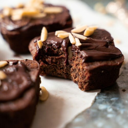 This picture shows three small batch chocolate brownies on a a piece of white parchment paper.