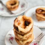 Three vegan pasteis de natat stacked on top of each other.